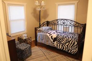 a zebra print bed in a room with two windows at Charming 2 bedroom Retreat minutes from Downtown in Tulsa