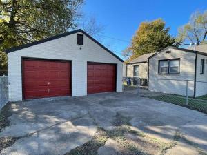 a garage with two red garage doors on a house at Charming 2 bedroom Retreat minutes from Downtown in Tulsa