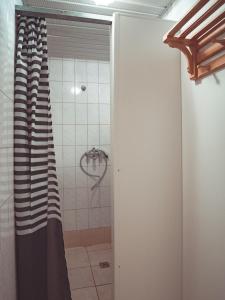 a shower with a black and white curtain in a bathroom at Energetikas • nameliai prie jūros in Šventoji