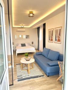 a living room with a blue couch and a bed at Hortus Apartments in Sveti Stefan