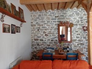 jadalnia ze stołem i kamienną ścianą w obiekcie Anastasia's Home w mieście Émbonas