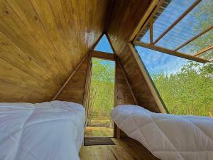 una camera da letto in una casa sull'albero con una grande finestra di Dumbo Eco Camp a Ozurgetʼi