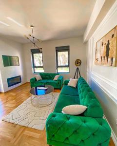 Apartman Barocco في تريبينيي: غرفة معيشة مع أريكة خضراء وطاولة