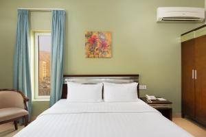 a bedroom with a large bed and a window at Centara Life Muscat Dunes Hotel in Muscat +18 photos