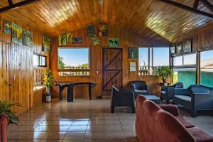 een kamer met stoelen, een tafel en ramen bij Hostel La Suerte in Monteverde Costa Rica