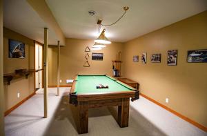 a room with a pool table in a room at Stoke Cabin by Revelstoke Vacations in Revelstoke