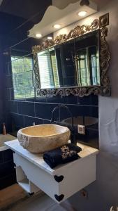 ein Badezimmer mit einem Steinwaschbecken und einem Spiegel in der Unterkunft Alegria rustica in Envendos