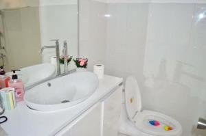 Baño blanco con lavabo y aseo en Cozy Vacation House in Guimaras, en Guimarás