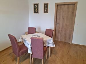 a dining room table with purple chairs and a door at Apartment NH12 in Bratislava