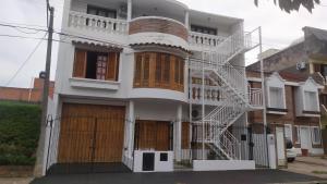 a white house with a white staircase on it at CASA BLANCA Jujuy in San Salvador de Jujuy