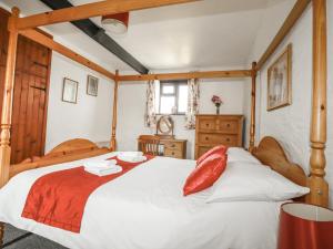 a bedroom with a large white bed with red pillows at Kestrel Corner in Lanivet