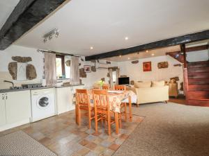 a kitchen and living room with a table and chairs at Foxes in Lanivet