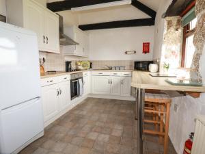 a kitchen with white cabinets and a wooden counter at Badgers Sett in Lanivet