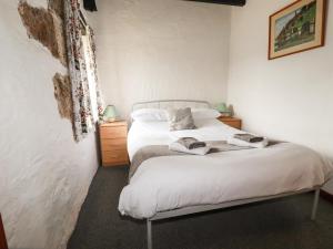 a bedroom with a white bed with towels on it at Badgers Sett in Lanivet