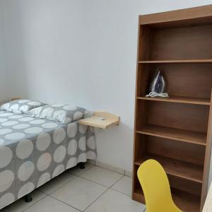 a bedroom with a bed and a yellow chair at Chales do delta Piauí in Parnaíba