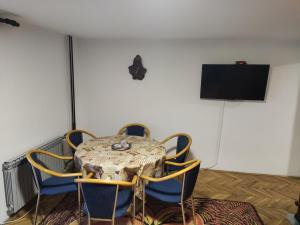 a table and chairs in a room with a television at PLANINSKA VILA SMIGIC in Divčibare