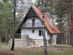 a white house with an orange roof in the woods at PLANINSKA VILA SMIGIC in Divčibare