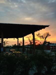 a sunset from a restaurant with a straw umbrella at Casa Losodeli & Coworking- Adults Only in Puerto Escondido