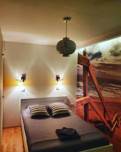 a bedroom with a bed with a painting on the wall at Alo Alo Apartman 6 in Kruševac