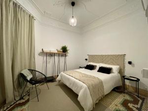 a white bedroom with a bed and a chair at Victoria Site-Luxury Center in Valencia