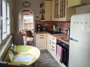 a kitchen with a white refrigerator and a table at holiday home, Berlin in Berlin