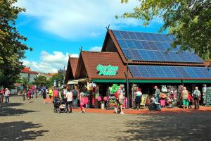 a group of people walking in front of a store with solar panels at Bungalow Am Spreeufer Lübben - DBS05100b-B in Lübben