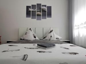 伯伊萊海爾庫拉內的住宿－Casa Fery，一间卧室配有一张带白色床单和照片的床