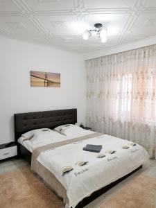 a bedroom with a large bed and a window at Casa Fery in Băile Herculane