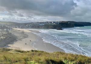 una spiaggia con persone che camminano sulla sabbia e sull'oceano di Luxury 3 bedroom caravan between Perranporth and Newquay, Cornwall a Newquay