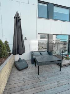 a patio with an umbrella and a couch and a bench at CITY CENTER Penthouse apartment in Oslo