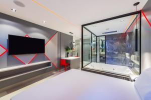a bedroom with a large window and a tv at Motel Mood in Sao Paulo