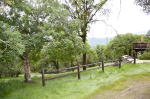 a wooden fence in a field with trees at Heavenly Gateway to Yosemite & Bass Lake in Oakhurst