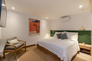 1 dormitorio con 1 cama grande y 1 silla en Villaz Luxury Vacation Homes, en Medellín