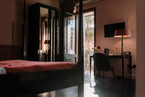 a bedroom with a bed and a table and a chair at Maison Matilda - Luxury Rooms in Treviso +39 photos