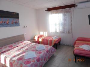 pokój hotelowy z 2 łóżkami i oknem w obiekcie B&B DiVino w mieście Cabras