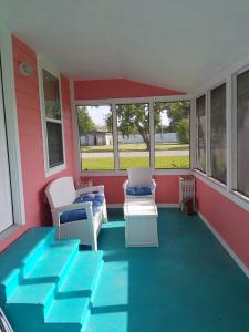 a screened in porch with chairs and tables at Coastal Cottage Bay House in Palacios +16 photos