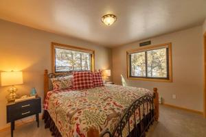 a bedroom with a bed and two windows at Scenic Pet-Friendly Mountain Getaway With Two Living Areas and Game Room - A Reel Good Time in Garo