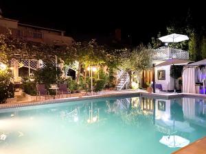 a swimming pool at night with an umbrella at Art Villa Ines in Zadar