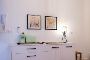 a white dresser with two pictures on the wall at Vista Corral del Conde in Seville +31 photos