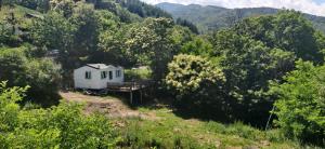 une petite maison blanche au milieu d'une forêt dans l'établissement After-Chèvres, à Villefort