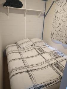 - un lit avec des draps noirs et blancs dans l'établissement After-Chèvres, à Villefort