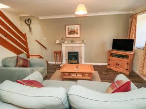 a living room with couches and a tv and a fireplace at Westgate Cottage in Pickering