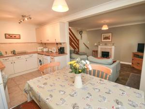 uma cozinha e sala de estar com uma mesa com flores em Westgate Cottage em Pickering