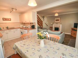 a kitchen and living room with a table with flowers on it at Westgate Cottage in Pickering