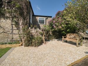 a bench sitting in front of a house with flowers at Westgate Cottage in Pickering