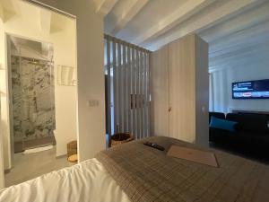 ミラノにあるBrera Charme Suiteのベッドと薄型テレビのある寝室