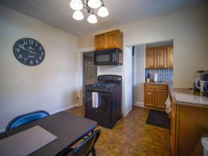 a kitchen with a stove and a clock on the wall at Cozy Large House close to TUFTS/Harvard/MIT 4BR in Medford +21 photos