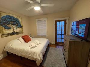 a bedroom with a bed and a flat screen tv at Cozy Large House close to TUFTS/Harvard/MIT 4BR in Medford