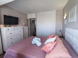 アルマカオ・デ・ペラにある7C Invicta - Casas & Papeisのピンクベッド1台、枕、テレビが備わるベッドルーム1室が備わります。