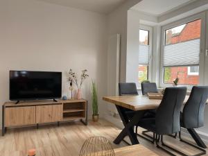 a living room with a dining table and a television at Kajüte 19 in Emden
